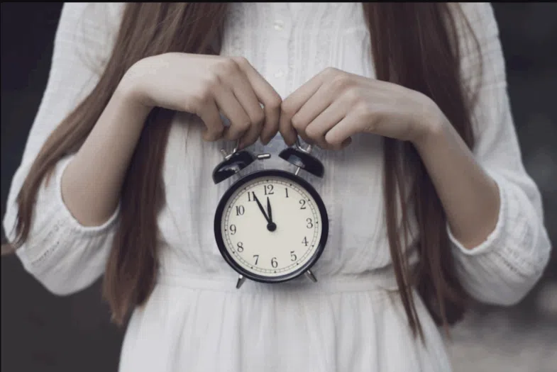 Femme devant fenêtre lumineuse le matin profitant exposition lumière naturelle au réveil