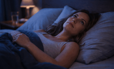 Femme souffrant d'insomnie allongée dans son lit la nuit regardant le plafond
