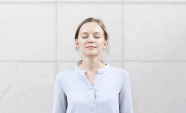 Personne pratiquant exercice respiration cohérence cardiaque position assise yeux fermés calme