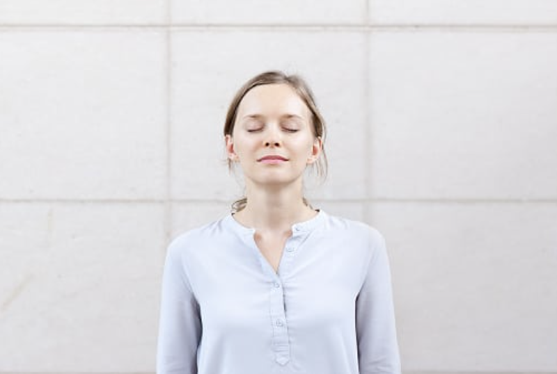 Personne pratiquant exercice respiration cohérence cardiaque position assise yeux fermés calme